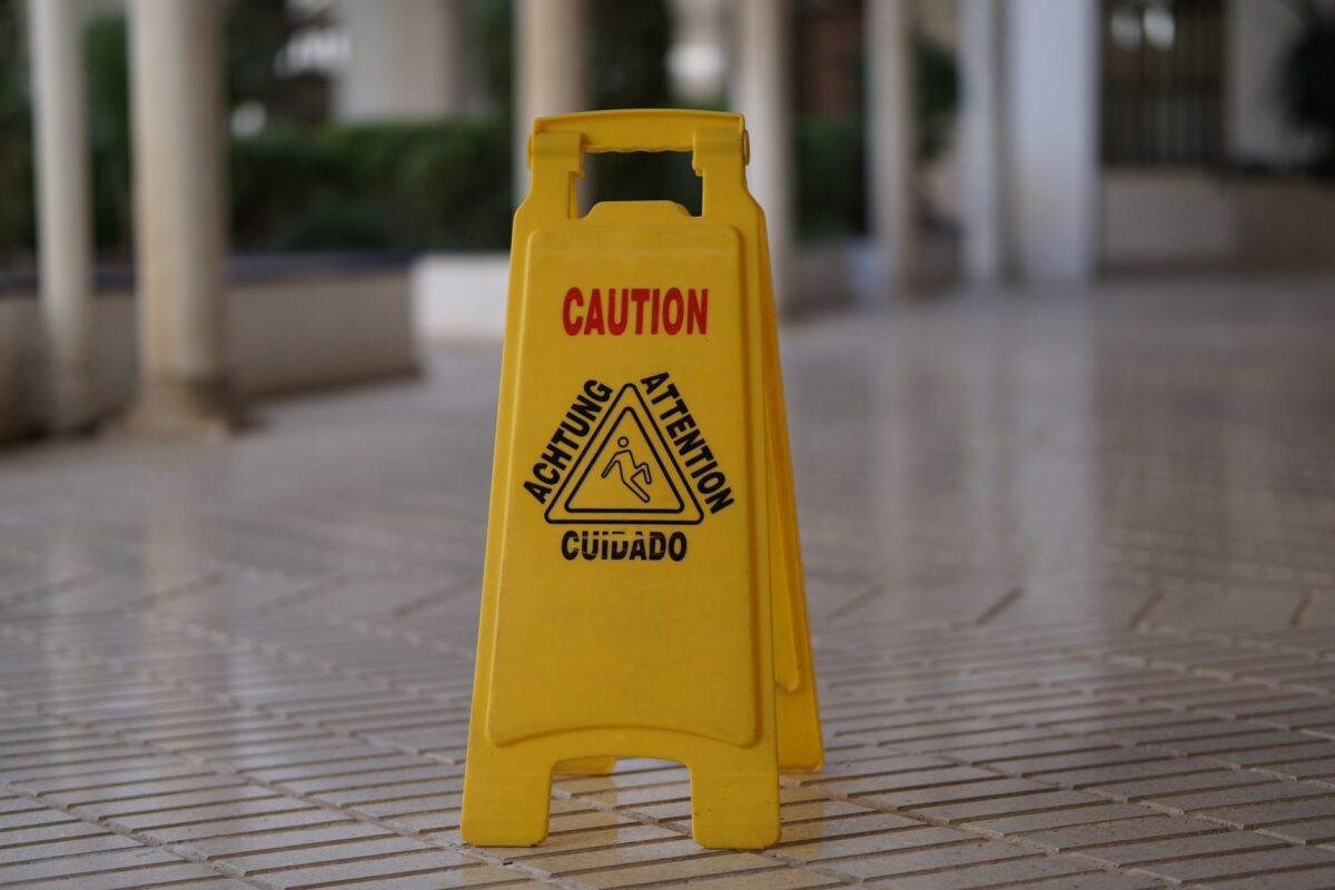 Caution wet floor sign on a tiled commercial entrance floor