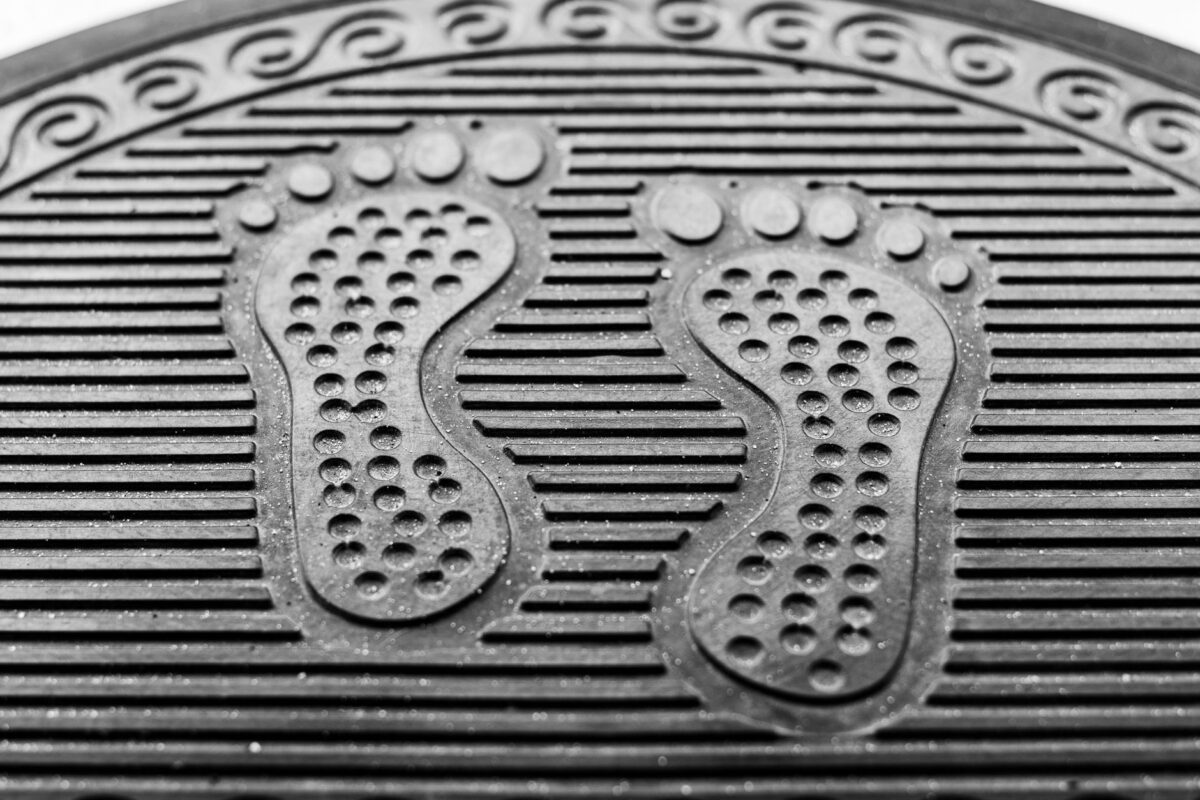 Ribbed black rubber scraper mat at a doorway